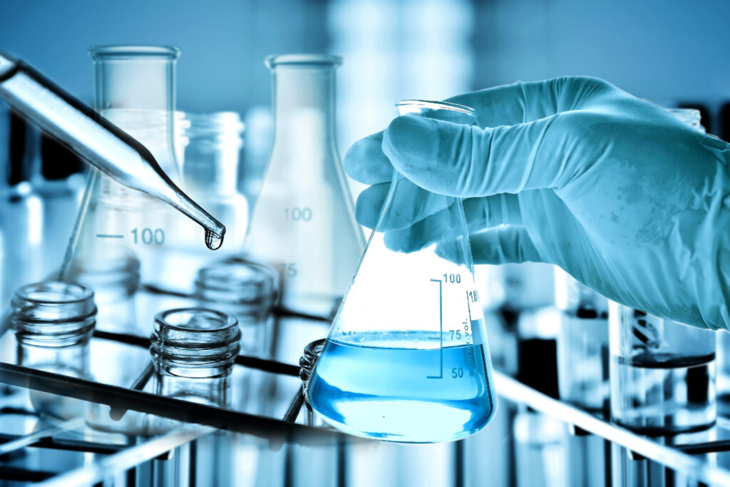 Flask in scientist hand with laboratory background